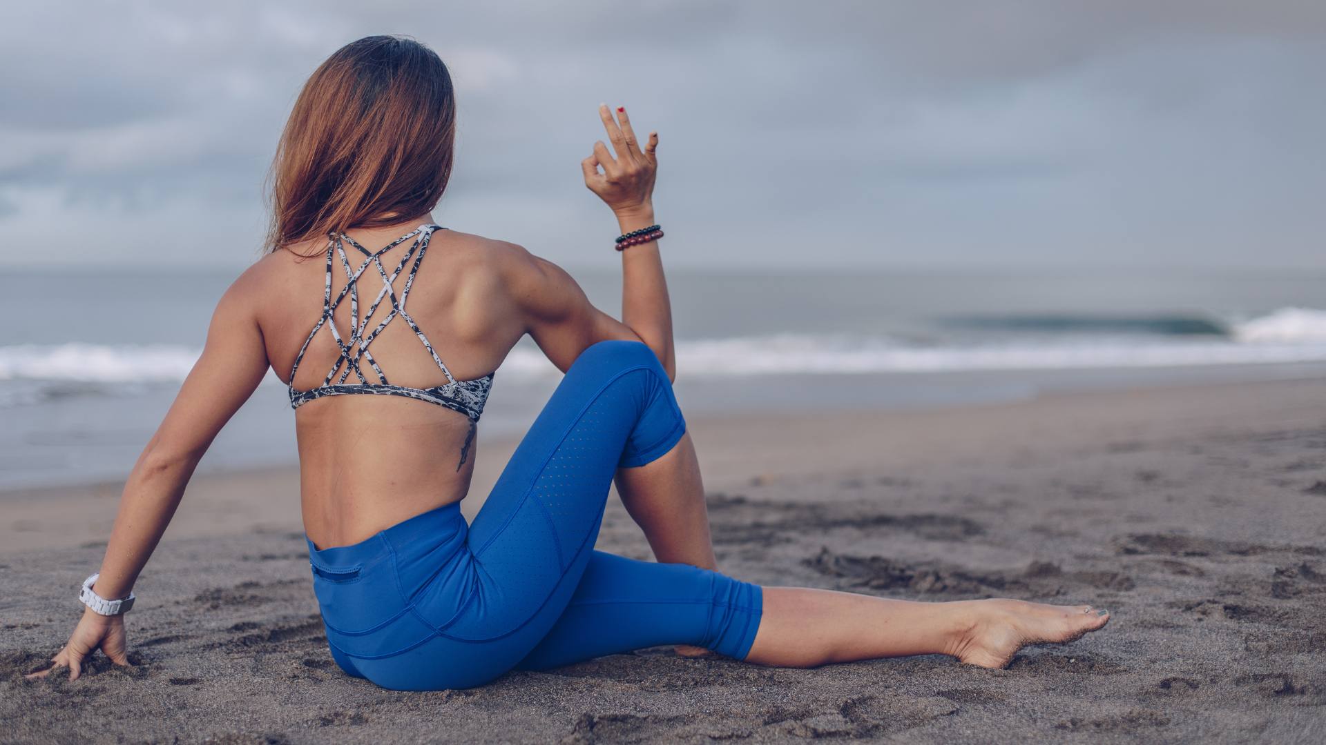ragazza fa yoga in spiaggia