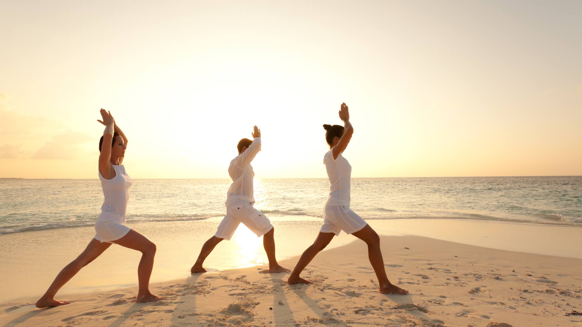 persone fanno yoga sulla spiaggia sulle isole toscane